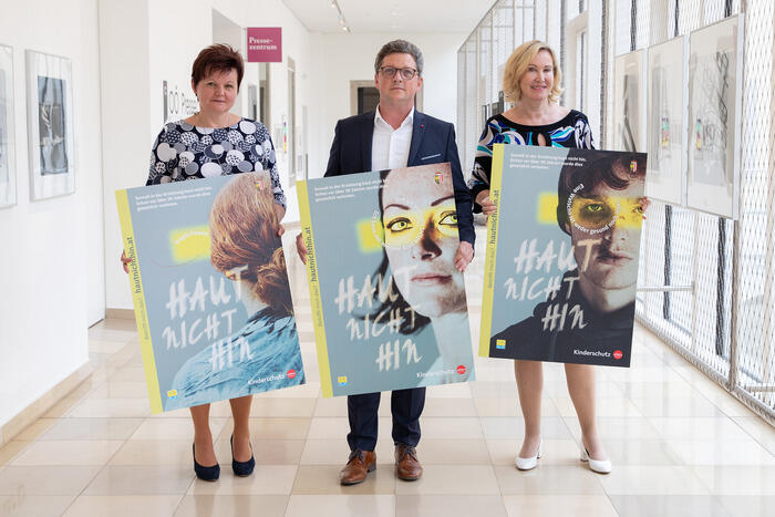 Theresia Schlöglmann, Leiterin der Kinder- und Jugendhilfe, Kinderschutz-Landesrat Michael Lindner und Kinder- und Jugendanwältin Christine Winkler-Kirchberger präsentieren die Plakate zur Gewaltschutz-Kampagne #haut nicht hin