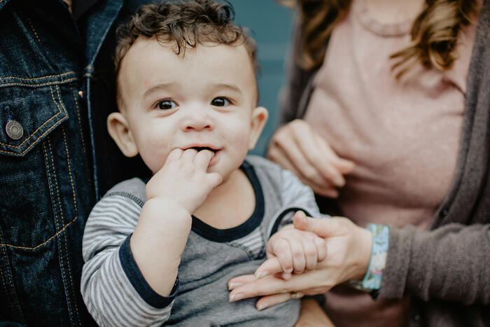 Baby wird von Eltern gehalten