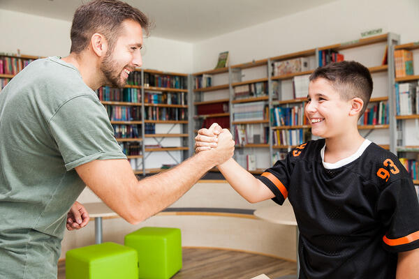 Mann und Junge machen einen Handschlag.