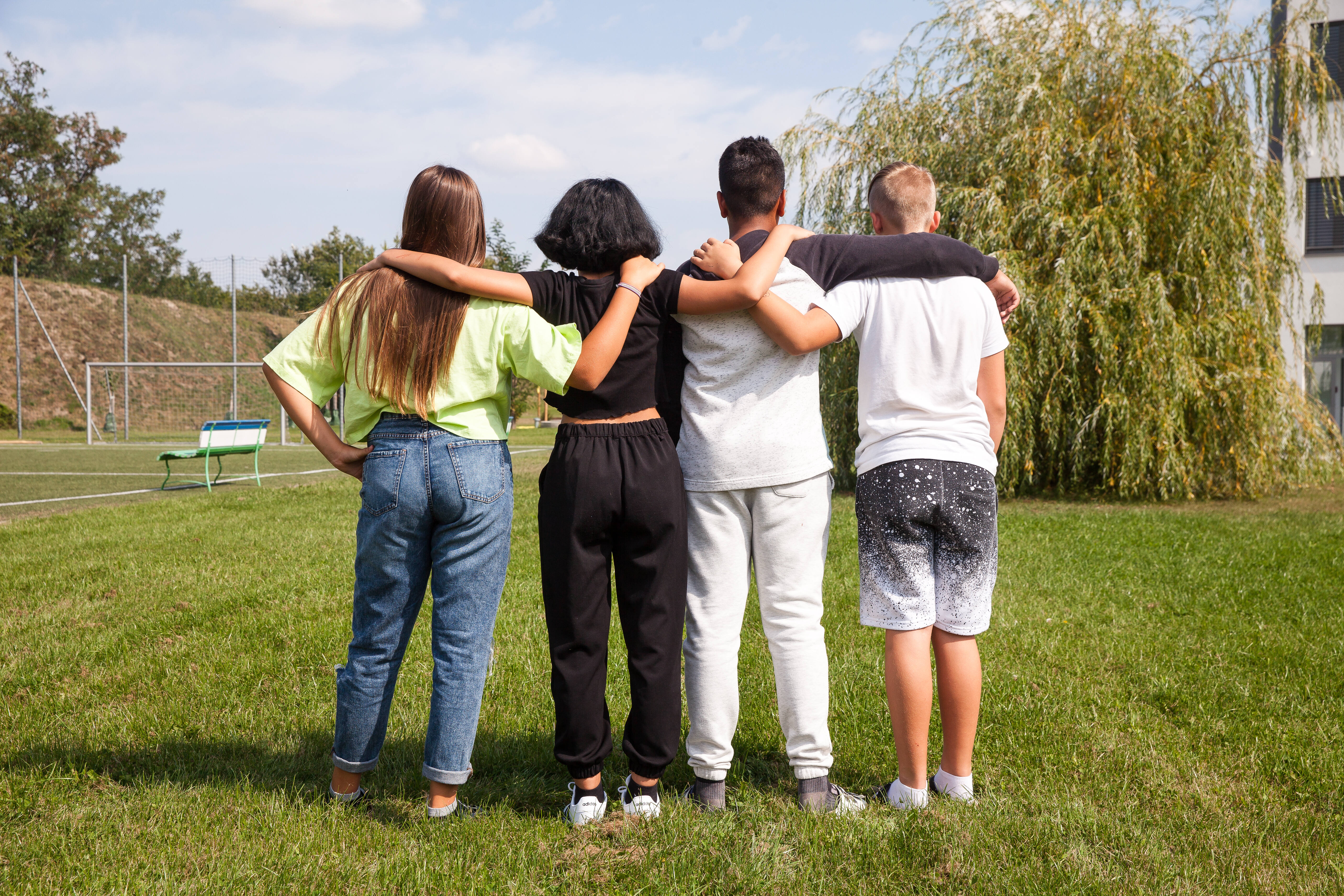 Gruppe_gemischt_umarmen_Natur_hinten_ruecken_Freunde_Kinder_und_Jugendanwaltschaft_OOE_KiJA_OOE_Kinderrechte