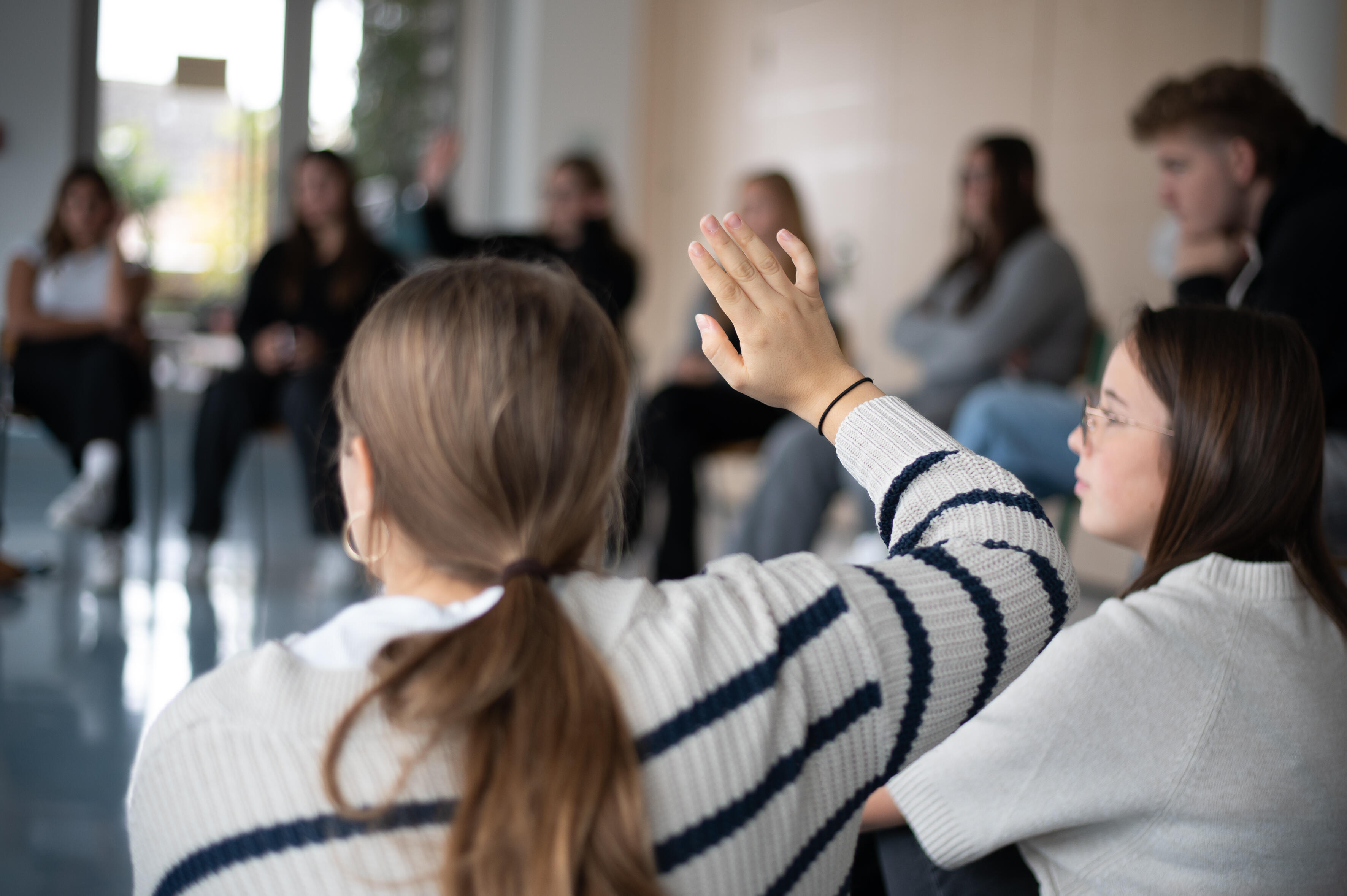 Schülerin zeigt im Unterricht auf